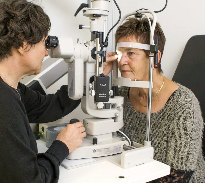 Øynene til kunde blir undersøkt av optiker
