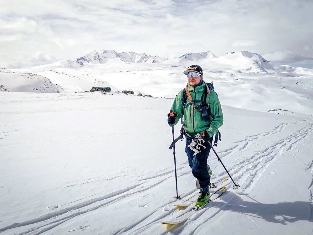 Mann på ski i fjellet med sportsbriller, skibriller