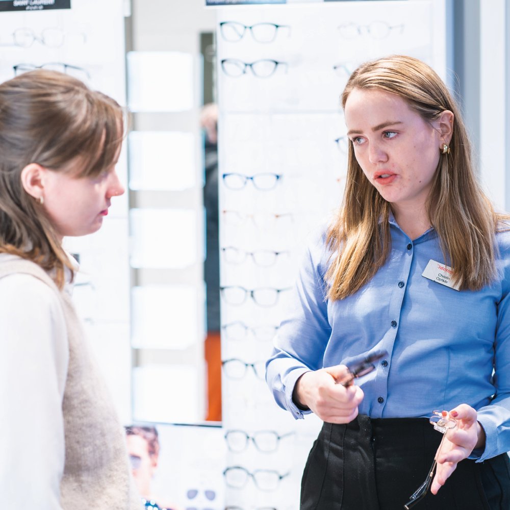 Optiker hjelper kunde med å velge innfatning