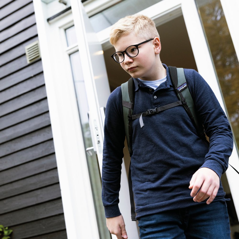 Ung gutt går til skolen iført nye MiYOSMART behandlingsbriller som bremser nærsynthet hos barn og unge.