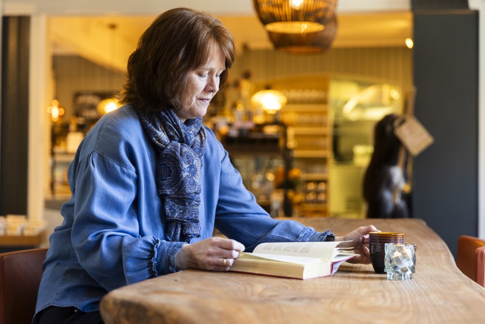 Solfrid leser på kafé, med multifocale linser for skjeve hornhinner fra  Acuvue 