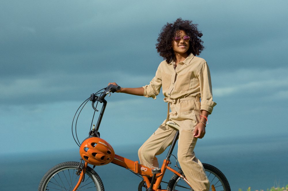 Ung jente med solbriller på sykkel