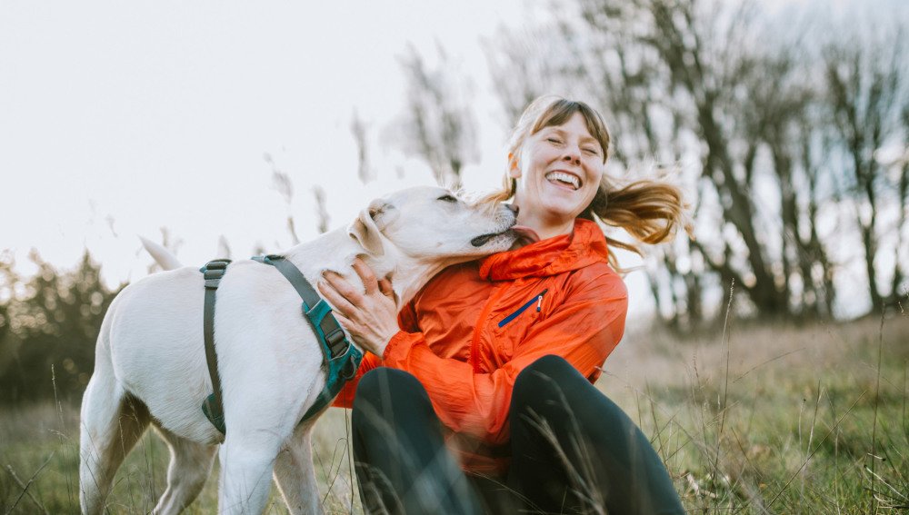 Ung kvinne med hund på tur