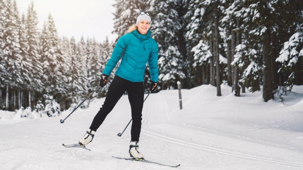 Jente på ski med solbriller på hodet