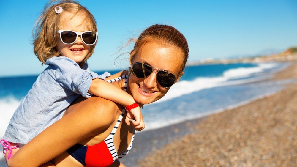 Mor og datter på stranden med solbriller