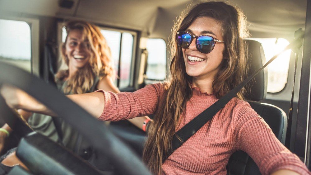 unge jenter på biltur med solbriller